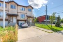Multi-level townhome exterior featuring an attached garage, covered entryway, and concrete driveway - 15713 102 Avenue Nw, Edmonton, AB  - Outdoor With Facade 