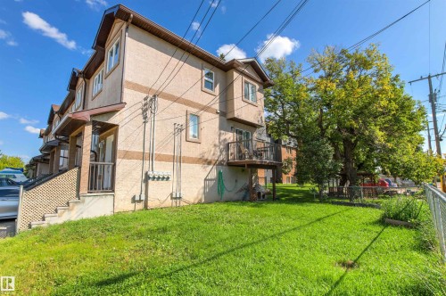 Stucco exterior with dormer windows, individual balconies, and a manicured lawn - 15713 102 Avenue Nw, Edmonton, AB - Outdoor