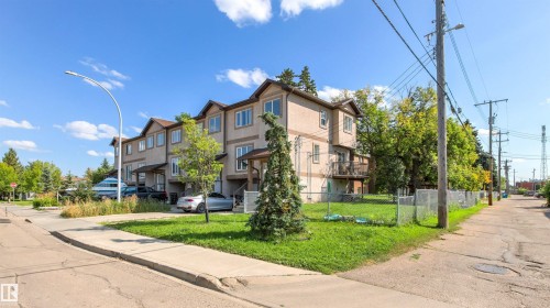 Multi-level exterior with stucco finish, individual balconies, and a paved sidewalk - 15713 102 Avenue Nw, Edmonton, AB - Outdoor
