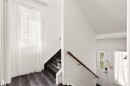 Dark wood-finish flooring with a matching staircase, white walls, and a window with sheer white drapery - 15713 102 Avenue Nw, Edmonton, AB  - Indoor Photo Showing Other Room 