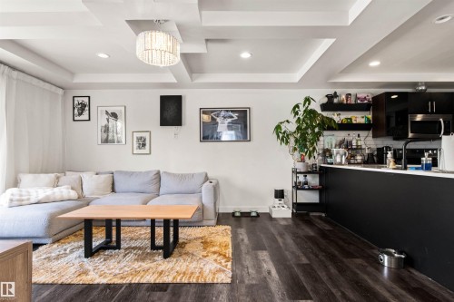 Open-concept living space with dark wood-finish flooring, recessed lighting, and a tray ceiling - 15713 102 Avenue Nw, Edmonton, AB - Indoor Photo Showing Living Room