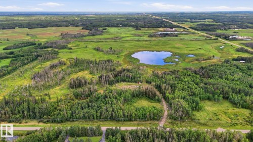 Extensive acreage featuring a natural pond, lush green fields, and mature tree coverage - 52012 Hwy 21, Rural Strathcona County, AB - Outdoor With View