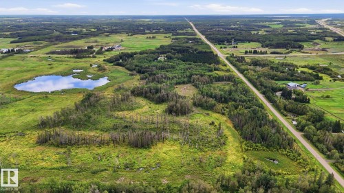 Expansive treed landscape with a visible pond and a distant highway - 52012 Hwy 21, Rural Strathcona County, AB - Outdoor With View