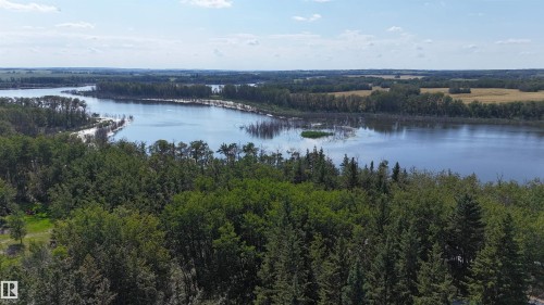 Expansive natural landscape featuring a prominent body of water, dense tree coverage, and distant agricultural fields under a bright sky - 347, 58532 Range Rd 113, Rural St. Paul County, AB 