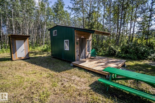 Compact structure with vertical green metal siding and wood-finish accents - 347, 58532 Range Rd 113, Rural St. Paul County, AB 