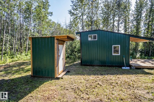 Green corrugated metal siding building with a wooden deck and overhang - 347, 58532 Range Rd 113, Rural St. Paul County, AB 