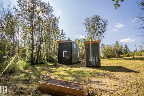 Wood-sided raised garden bed, two structures with dark green siding, and a surrounding natural landscape - 347, 58532 Range Rd 113, Rural St. Paul County, AB 