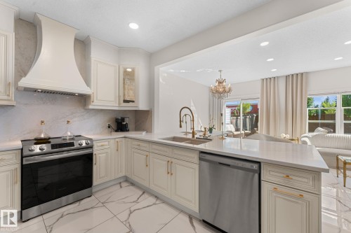 Kitchen featuring stone countertops, stainless steel appliances, custom cabinetry, a built-in range hood, and tile flooring - 5415 167A Avenue Nw, Edmonton, AB - Indoor Photo Showing Kitchen With Upgraded Kitchen