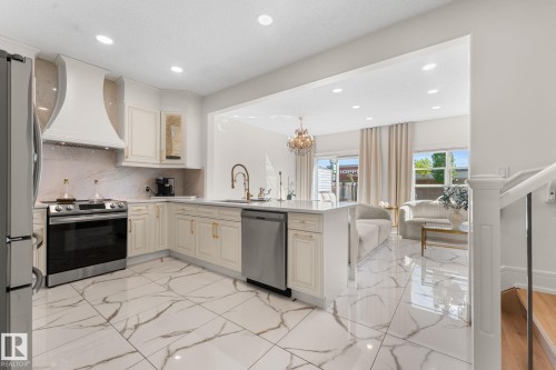 Gourmet kitchen with stainless steel appliances, custom range hood, and white cabinetry - 5415 167A Avenue Nw, Edmonton, AB - Indoor Photo Showing Kitchen