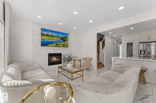 Open-concept living area with a stone-clad fireplace and recessed lighting - 5415 167A Avenue Nw, Edmonton, AB - Indoor Photo Showing Living Room With Fireplace