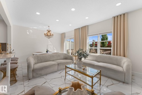 Recessed lighting, tile flooring with veining, and a crystal chandelier - 5415 167A Avenue Nw, Edmonton, AB - Indoor Photo Showing Living Room