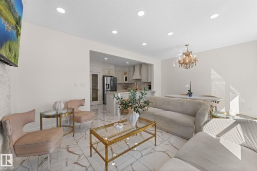 Recessed ceiling lighting, a decorative chandelier, white tile flooring, and light-colored walls - 5415 167A Avenue Nw, Edmonton, AB - Indoor Photo Showing Living Room