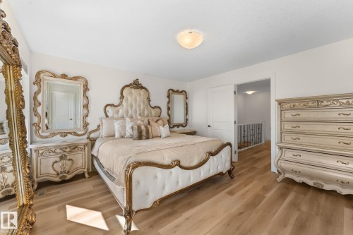 Wood-finish flooring with light-toned walls and a flush-mount ceiling light - 5415 167A Avenue Nw, Edmonton, AB - Indoor Photo Showing Bedroom