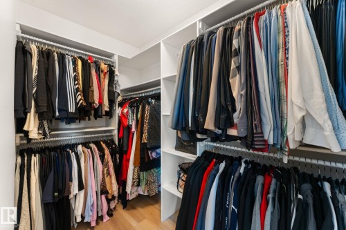 Custom closet system featuring multiple hanging rods and integrated shelving - 5415 167A Avenue Nw, Edmonton, AB - Indoor With Storage