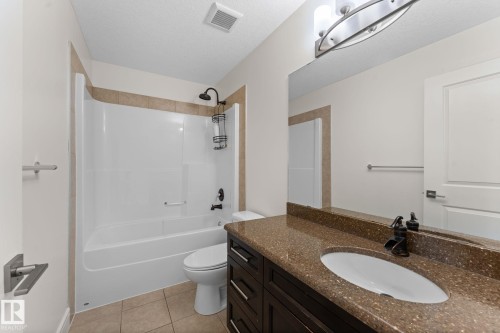 Integrated bathtub and shower with brown tile surround - 5415 167A Avenue Nw, Edmonton, AB - Indoor Photo Showing Bathroom
