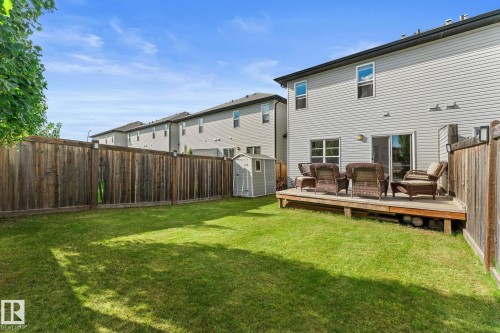 Expansive green lawn with a wood-plank deck, sliding glass door, and a storage shed - 5415 167A Avenue Nw, Edmonton, AB - Outdoor With Deck Patio Veranda With Backyard With Exterior