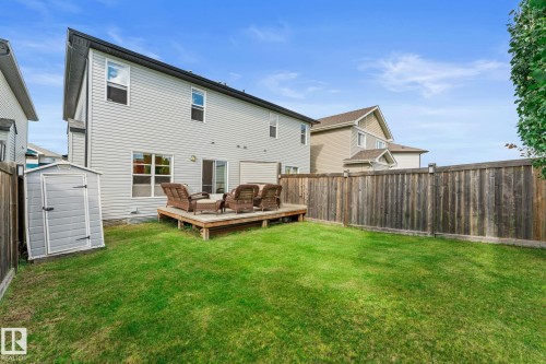 Expansive backyard with a wooden fence, green lawn, and a ground-level deck - 5415 167A Avenue Nw, Edmonton, AB - Outdoor With Exterior