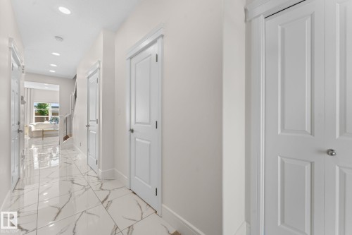 Hallway featuring recessed lighting, panel doors, a bi-fold closet, and polished tile flooring - 5415 167A Avenue Nw, Edmonton, AB - Indoor Photo Showing Other Room