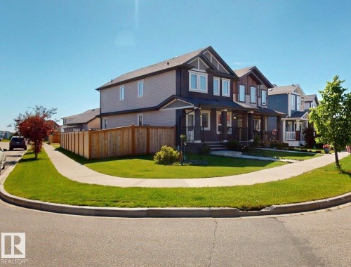 Exterior featuring a gabled roofline, mixed siding, covered front porch, and a wooden privacy fence - 17359 49 Street Nw, Edmonton, AB - Outdoor With Deck Patio Veranda With Facade