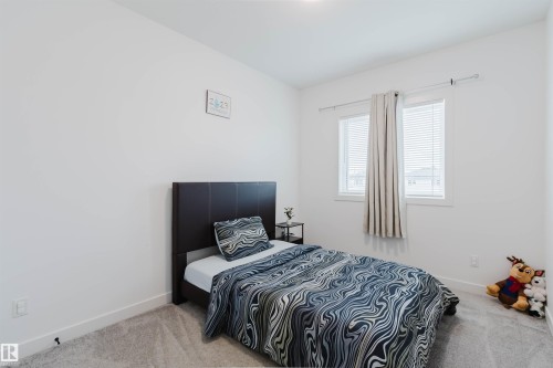 White painted walls, light gray carpet flooring, and dual windows with blinds - 104 Meadowview Way, Leduc, AB - Indoor Photo Showing Bedroom