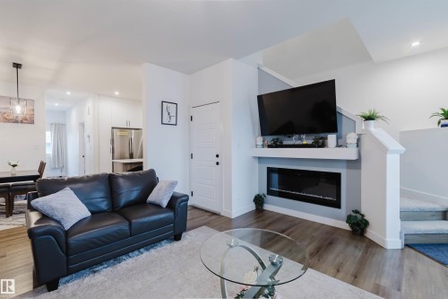 Wood-finish flooring throughout the main level - 104 Meadowview Way, Leduc, AB - Indoor Photo Showing Living Room With Fireplace