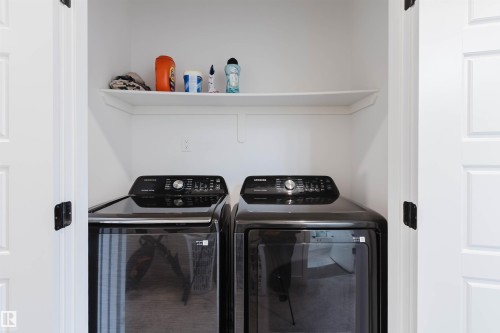 Laundry area featuring a built-in shelf and white paneled doors with dark hardware - 104 Meadowview Way, Leduc, AB - Indoor Photo Showing Laundry Room