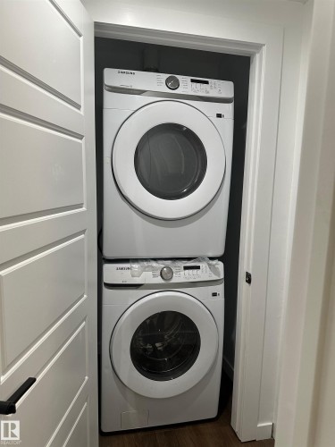 Stackable laundry appliances within a dedicated utility closet - 104 Meadowview Way, Leduc, AB - Indoor Photo Showing Laundry Room