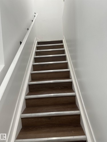 Staircase with wood-finish treads and white risers - 104 Meadowview Way, Leduc, AB - Indoor Photo Showing Other Room