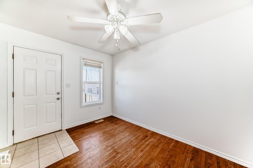 Wood-finish flooring, white walls, and a ceiling fan - 11727 83 Street Nw, Edmonton, AB - Indoor Photo Showing Other Room