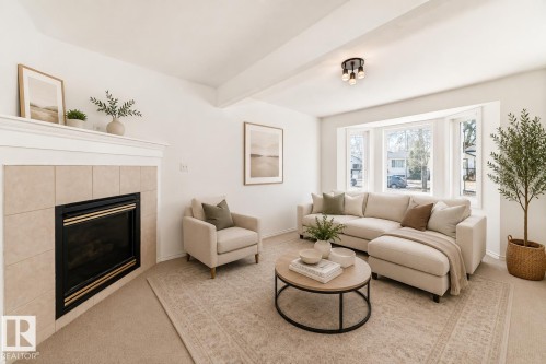 Virtually staged room with illustrating potential of room with furniture, decor and new flooring show a recessed fireplace with a tile surround and mantel - 11727 83 Street Nw, Edmonton, AB - Indoor Photo Showing Living Room With Fireplace
