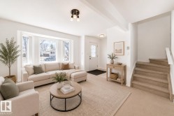 Virtually staged room with illustrating potential of room with furniture, decor and new flooring show a bright living room with a bay window, recessed lighting, and a front entry door with decorative glass - 