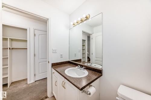 Vanity with a built-in sink and countertop, large wall-mounted mirror, and overhead lighting fixture - 11727 83 Street Nw, Edmonton, AB - Indoor Photo Showing Bathroom