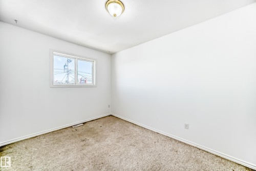 Carpeted room with a flush-mount ceiling light fixture, white walls, and a window with white trim - 11727 83 Street Nw, Edmonton, AB - Indoor Photo Showing Other Room
