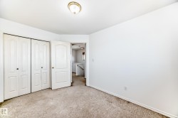 Neutral-toned carpeting, white walls, white bi-fold closet doors, and an overhead flush-mount light fixture - 