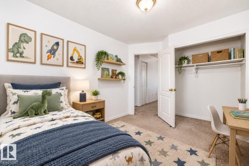 Virtually staged room with illustrating potential of room with furniture, decor and new flooring show a built-in closet shelving, neutral wall color, carpet flooring, a natural wood-finish nightstand, and floating wall shelves - 11727 83 Street Nw, Edmonton, AB - Indoor Photo Showing Bedroom