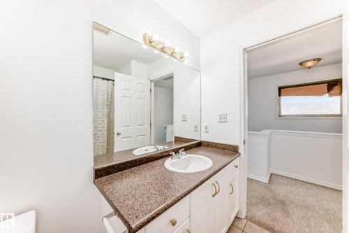 Bathroom vanity with an integrated sink, a speckled countertop, and a large wall-mounted mirror - 11727 83 Street Nw, Edmonton, AB - Indoor Photo Showing Bathroom