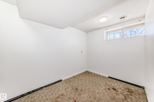 Recessed ceiling lighting, white painted walls, and a single window with a security grilles - 11727 83 Street Nw, Edmonton, AB - Indoor Photo Showing Other Room