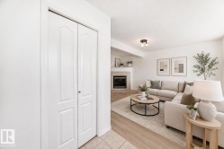 Virtually staged room with illustrating potential of room with furniture, decor and new flooring show a bright, open-concept living area featuring a wood-finish plank floor, neutral paint throughout, and abundant natural light - 