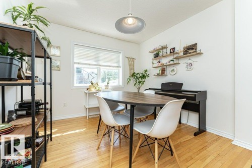 Recessed window with blinds, wood-finish flooring, built-in shelving, and overhead lighting fixture - 1539 Kinross Road Nw, Edmonton, AB - Indoor Photo Showing Dining Room