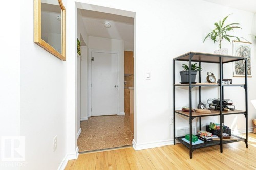 Hardwood flooring throughout the main area and a doorway leading to an interior space with textured flooring - 1539 Kinross Road Nw, Edmonton, AB - Indoor