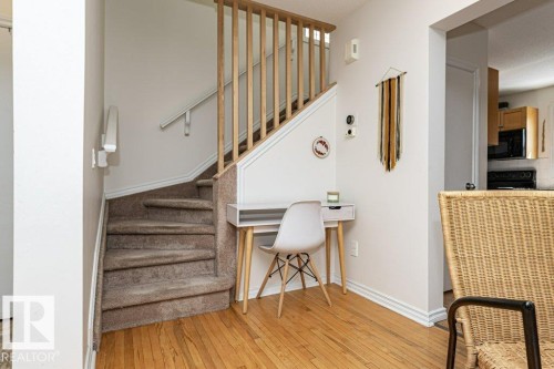 Hardwood flooring, carpeted staircase, wood balusters, and a built-in under-stair desk niche - 1539 Kinross Road Nw, Edmonton, AB - Indoor Photo Showing Other Room
