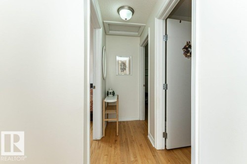 Hardwood flooring throughout the hallway with white trim and a flush-mounted ceiling light fixture - 1539 Kinross Road Nw, Edmonton, AB - Indoor Photo Showing Other Room
