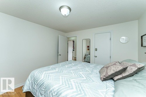 Wood-finish flooring, white walls, and a flush mount ceiling light - 1539 Kinross Road Nw, Edmonton, AB - Indoor Photo Showing Bedroom