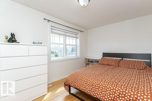 Wood-finish flooring, white walls, and a multi-pane window with blinds - 1539 Kinross Road Nw, Edmonton, AB - Indoor Photo Showing Bedroom