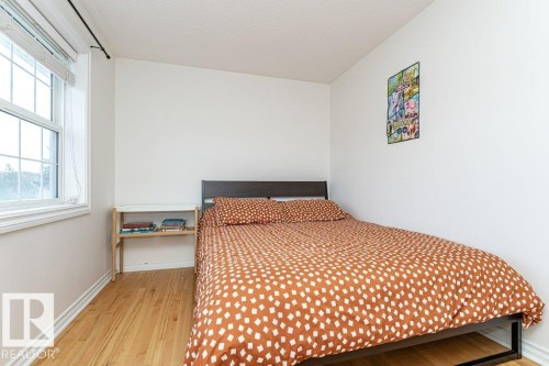 Wood-finish flooring, white walls, and a multi-pane window with blinds - 1539 Kinross Road Nw, Edmonton, AB - Indoor Photo Showing Bedroom