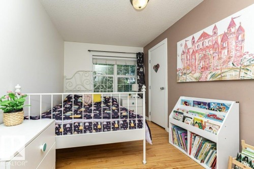 Hardwood flooring, painted walls, white trim, and a built-in bookshelf - 1539 Kinross Road Nw, Edmonton, AB - Indoor Photo Showing Other Room