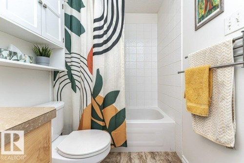 Bathtub with white tile surround - 1539 Kinross Road Nw, Edmonton, AB - Indoor Photo Showing Bathroom