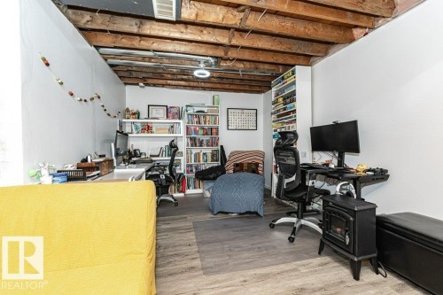 Exposed wood ceiling beams, recessed lighting, wood-finish flooring, built-in shelving, and white painted walls - 1539 Kinross Road Nw, Edmonton, AB - Indoor