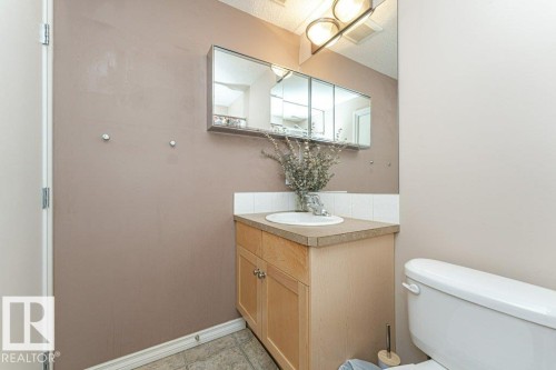 Wood-finish vanity with an integrated sink and countertop - 1539 Kinross Road Nw, Edmonton, AB - Indoor Photo Showing Bathroom