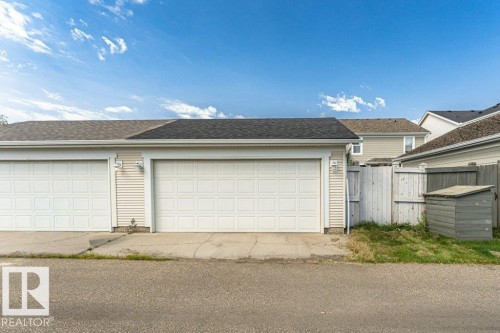 Two-car garage featuring panel-style doors and exterior wall sconces - 1539 Kinross Road Nw, Edmonton, AB - Outdoor With Exterior